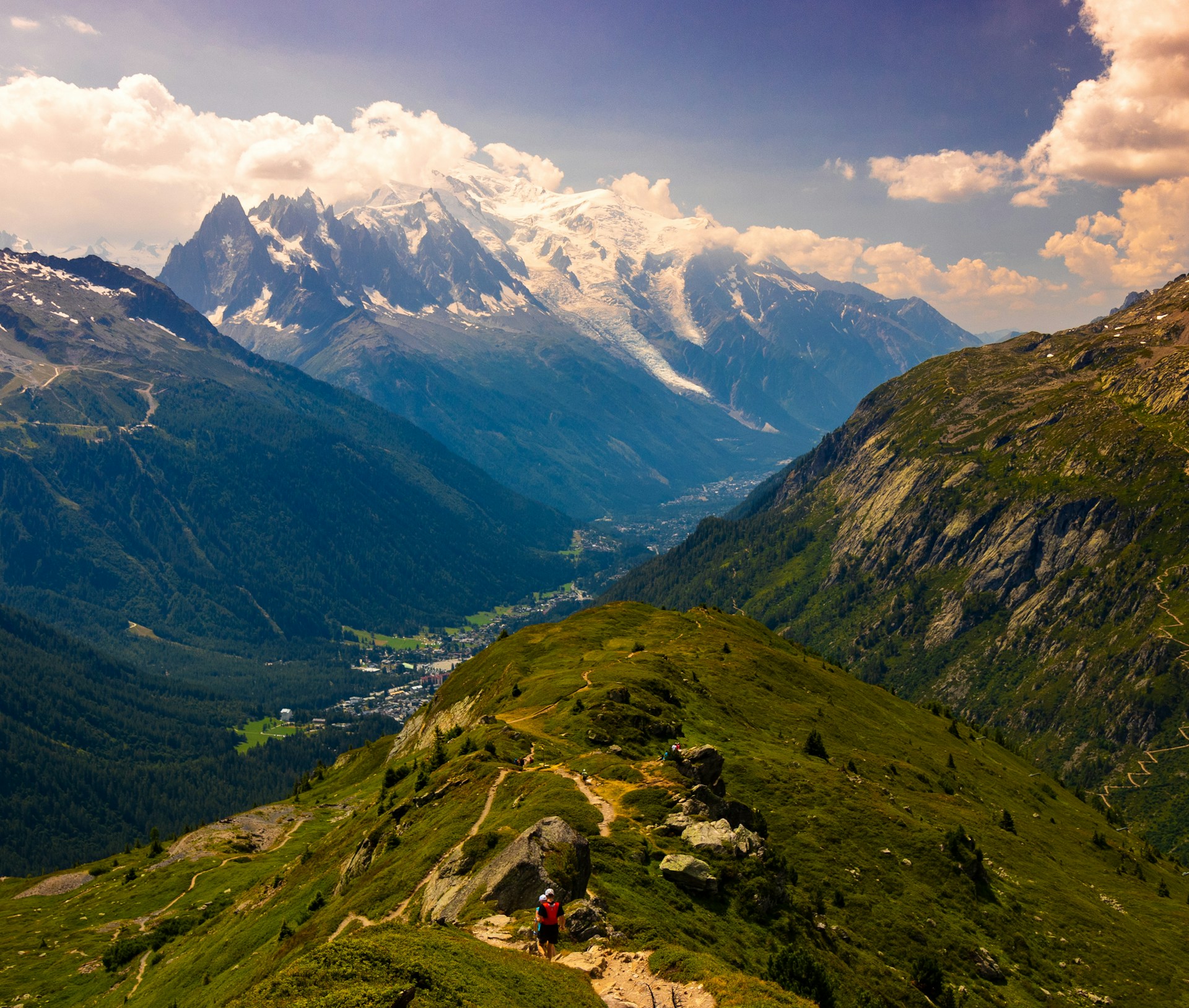 Hikers traversing green alpine slopes near Mont Blanc, France
