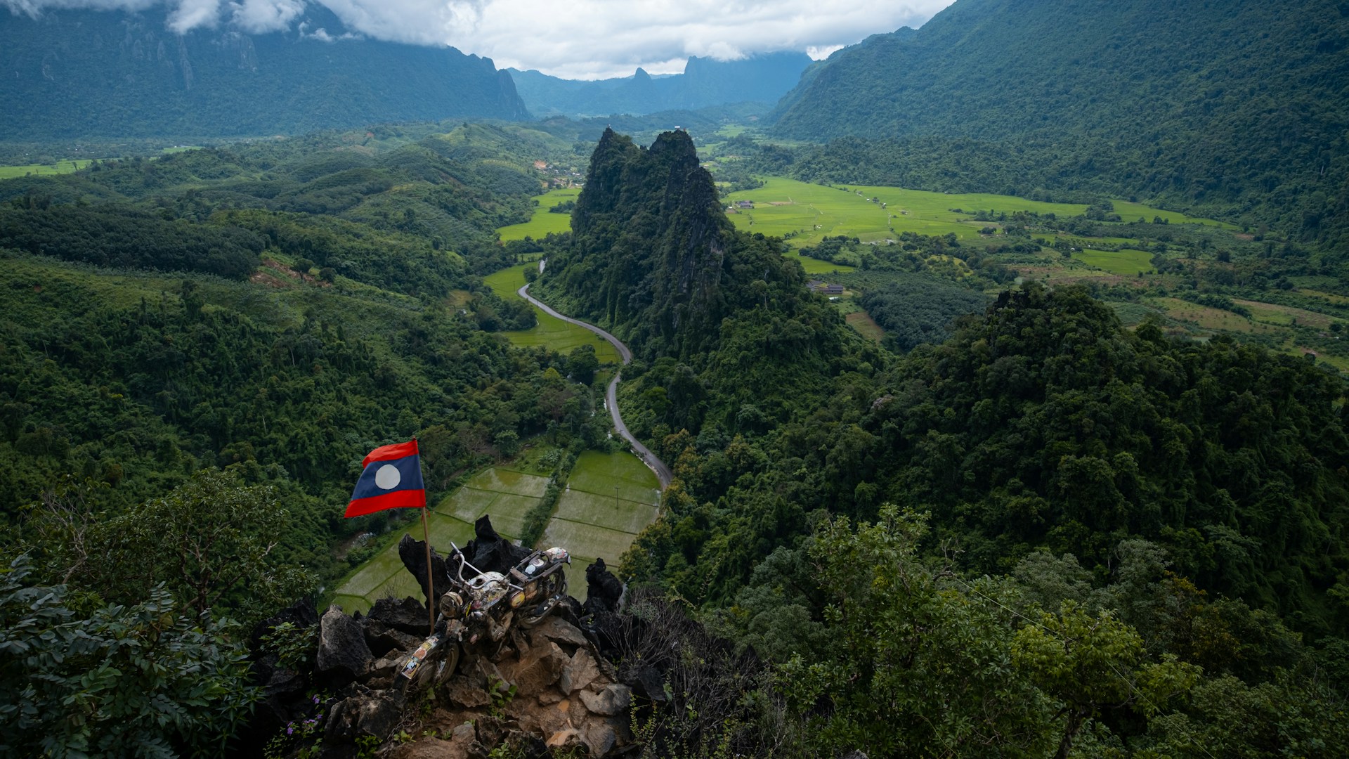 A winding road through the green mountain valleys of Laos