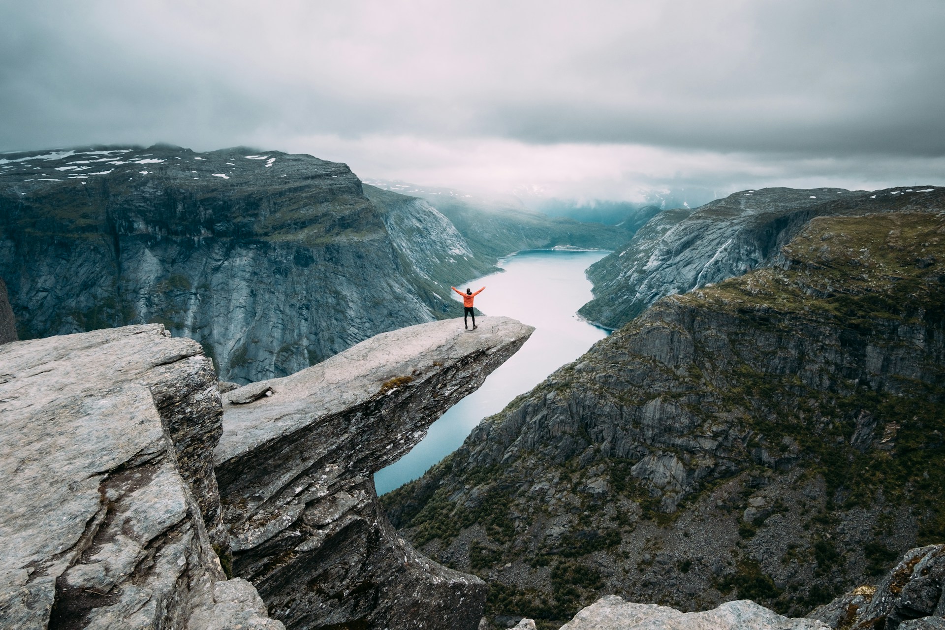 A hiker standing on the Trolltunga rock formation in Norway