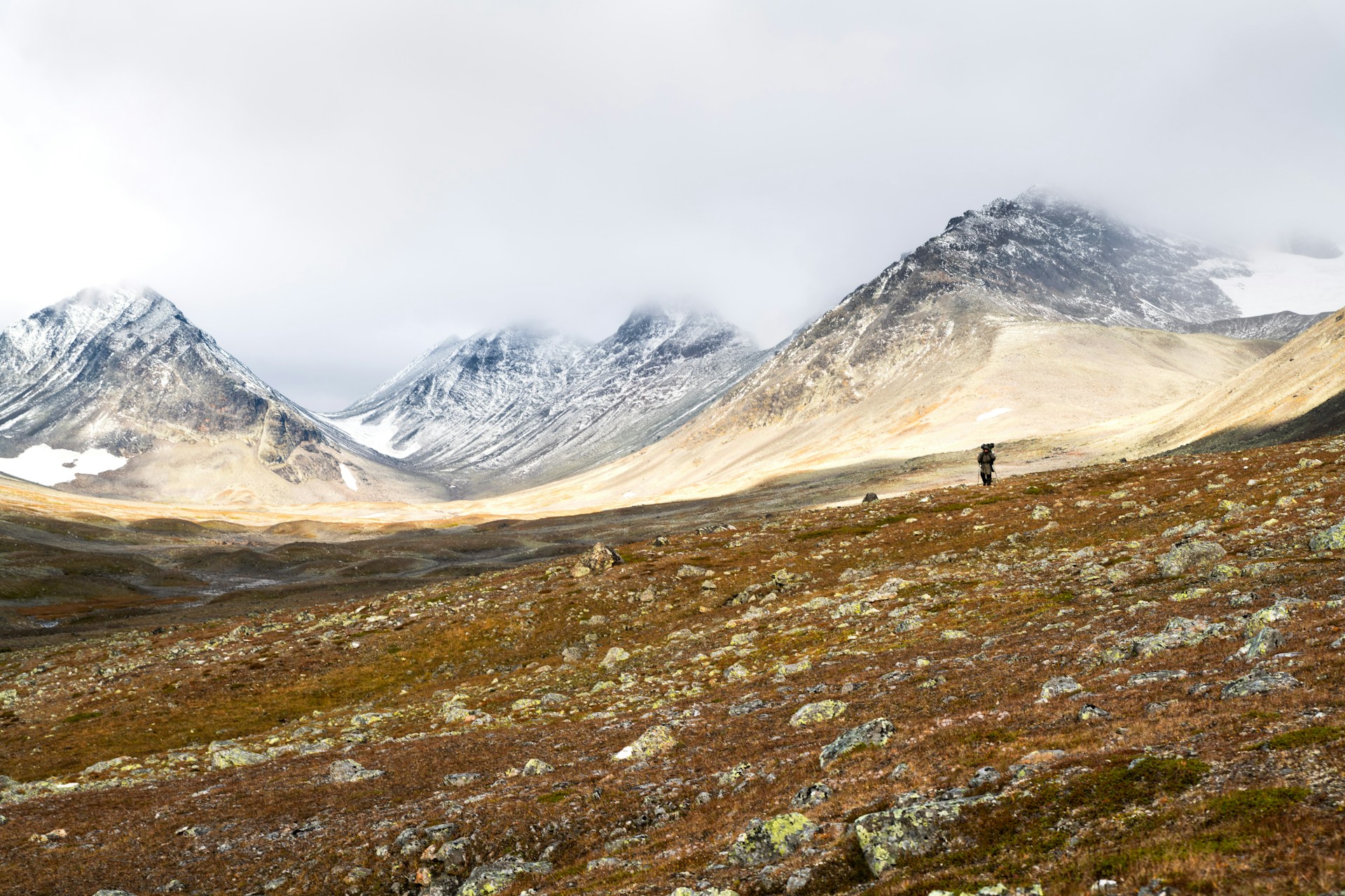A hiker overlooking the mountain valleys of Sarek National Park at sunrise