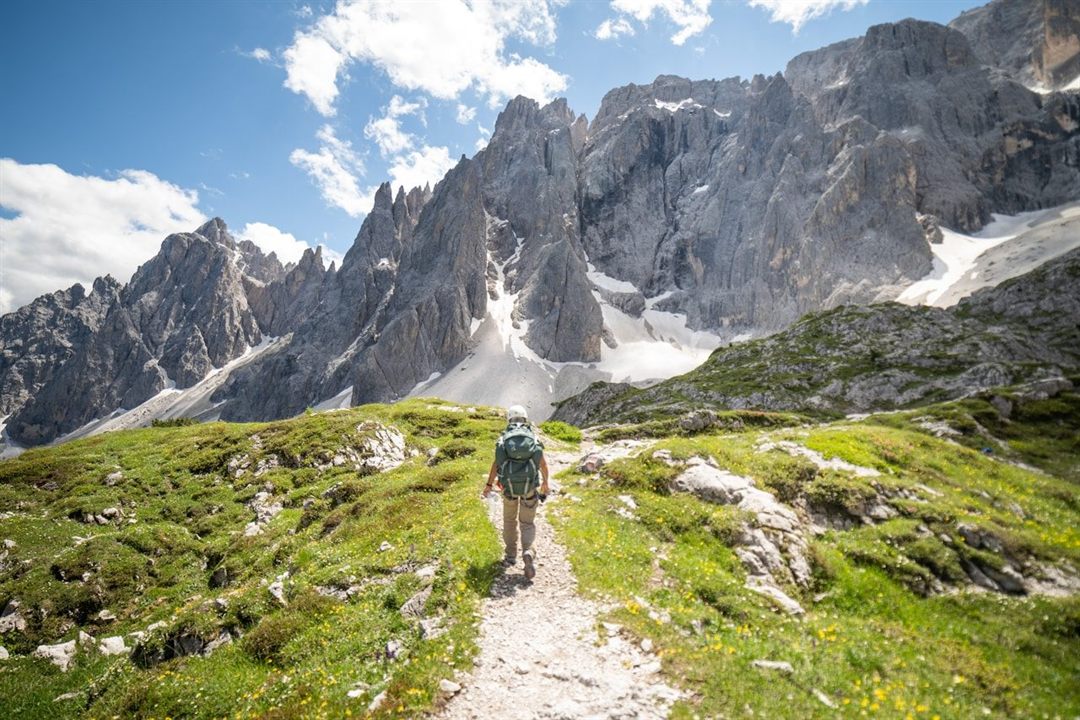A hiker following a mountain trail through the Italian Dolomites
