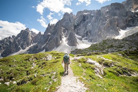 A hiker following a mountain trail through the Italian Dolomites