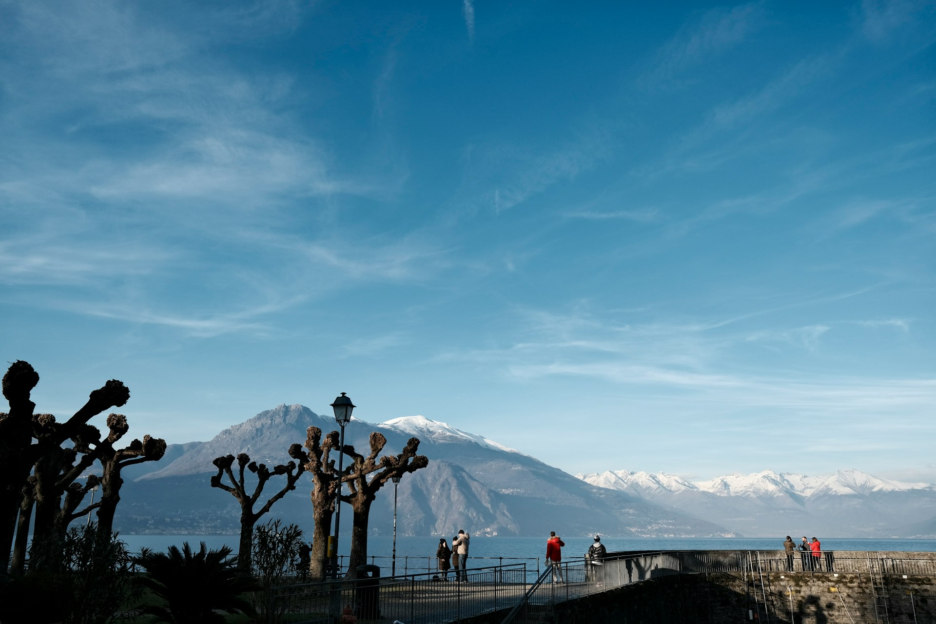 Hikers on a mountain path overlooking Lake Como