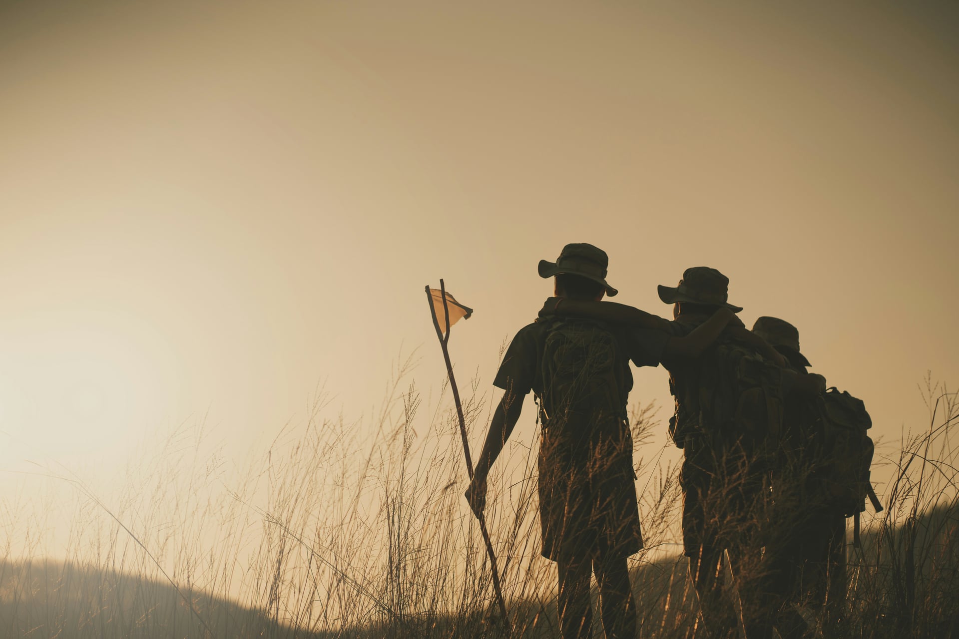 A group of young scouts hiking together across open countryside