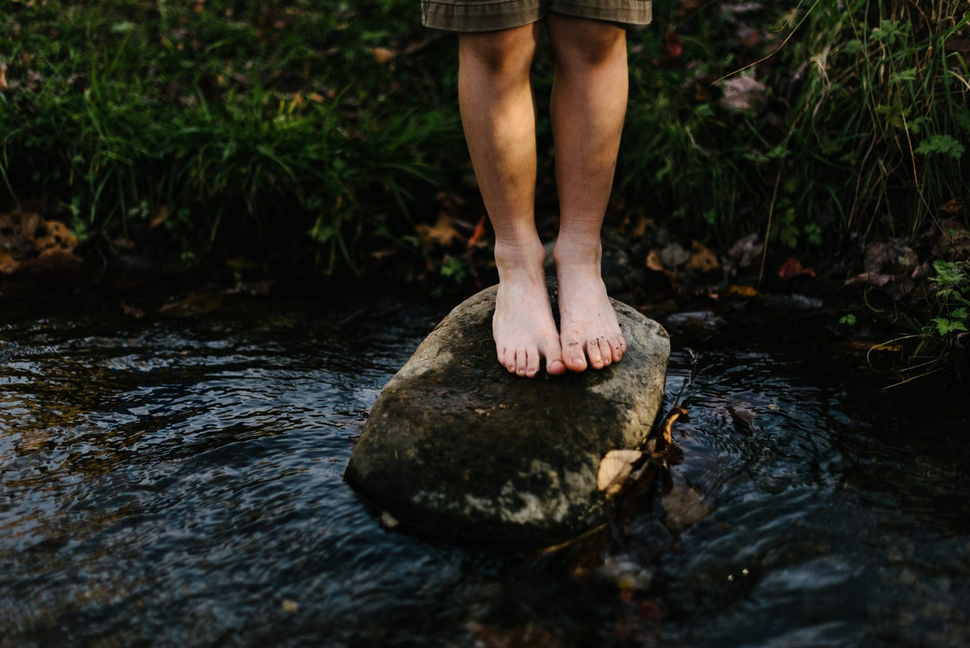 barefoot hiker crossing river