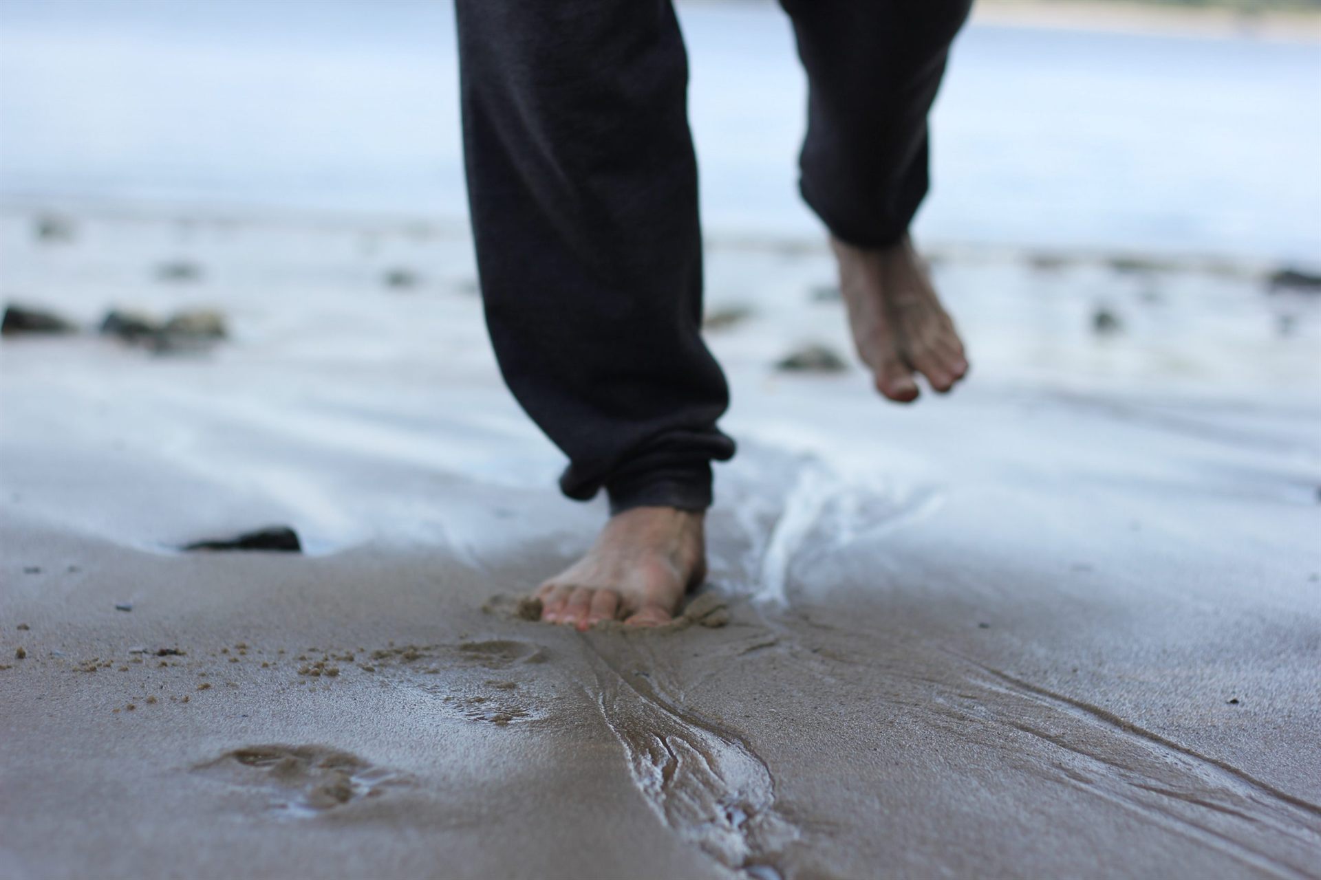 person walking barefoot on the beach