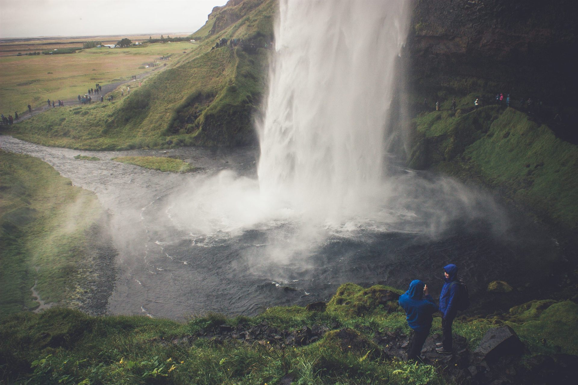hikers in front of waterfall