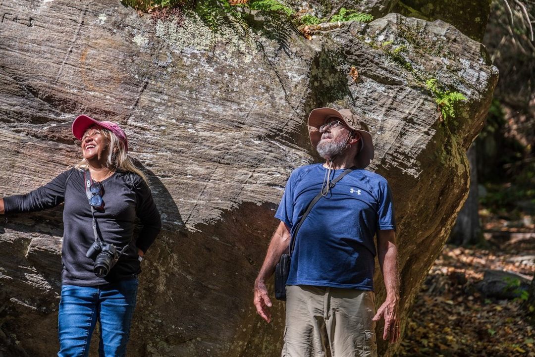 Hikers beside a large rock outcrop on Monument Mountain in Massachusetts