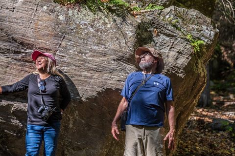 Hikers beside a large rock outcrop on Monument Mountain in Massachusetts