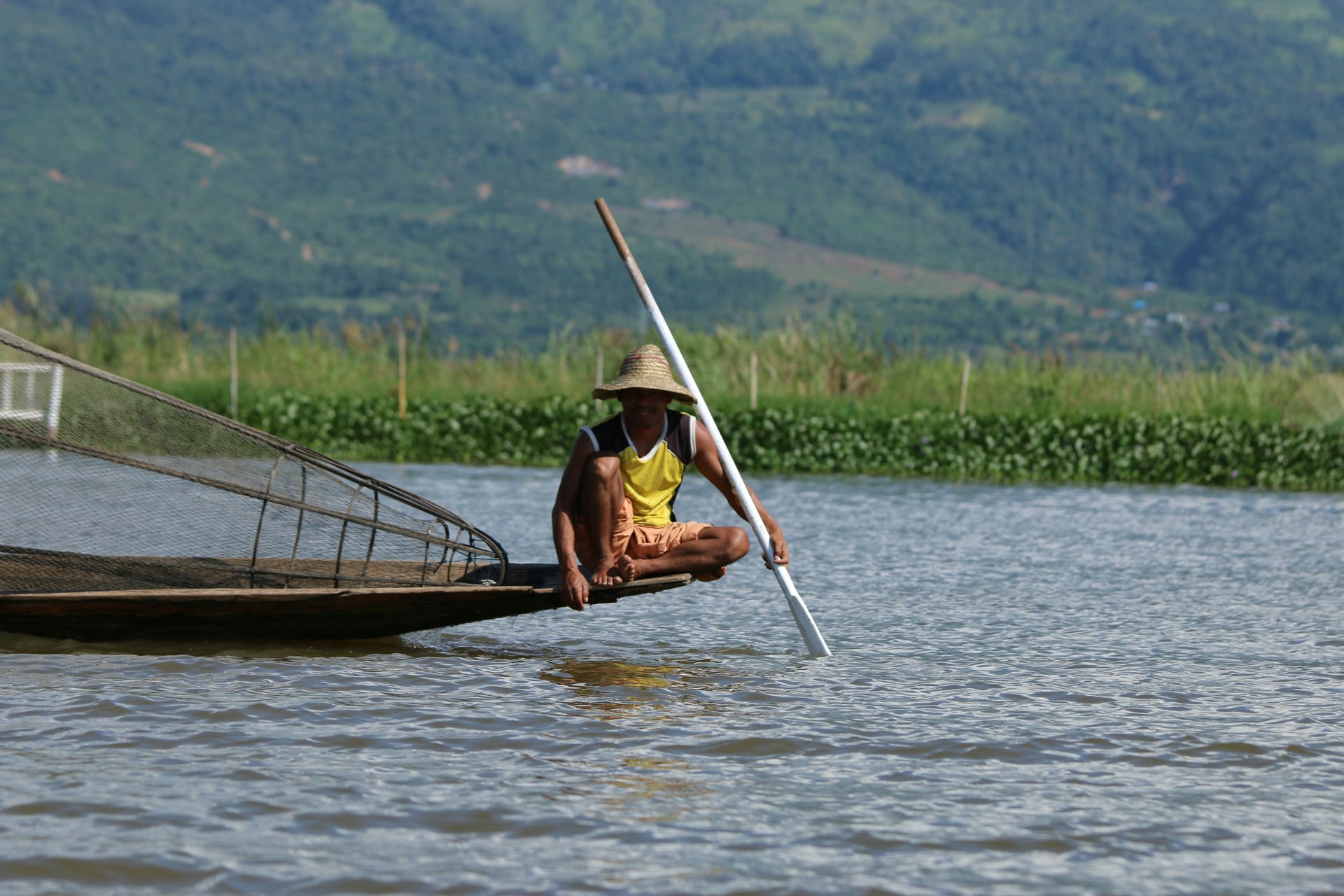 A traditional fisherman rowing across Inle Lake in Myanmar
