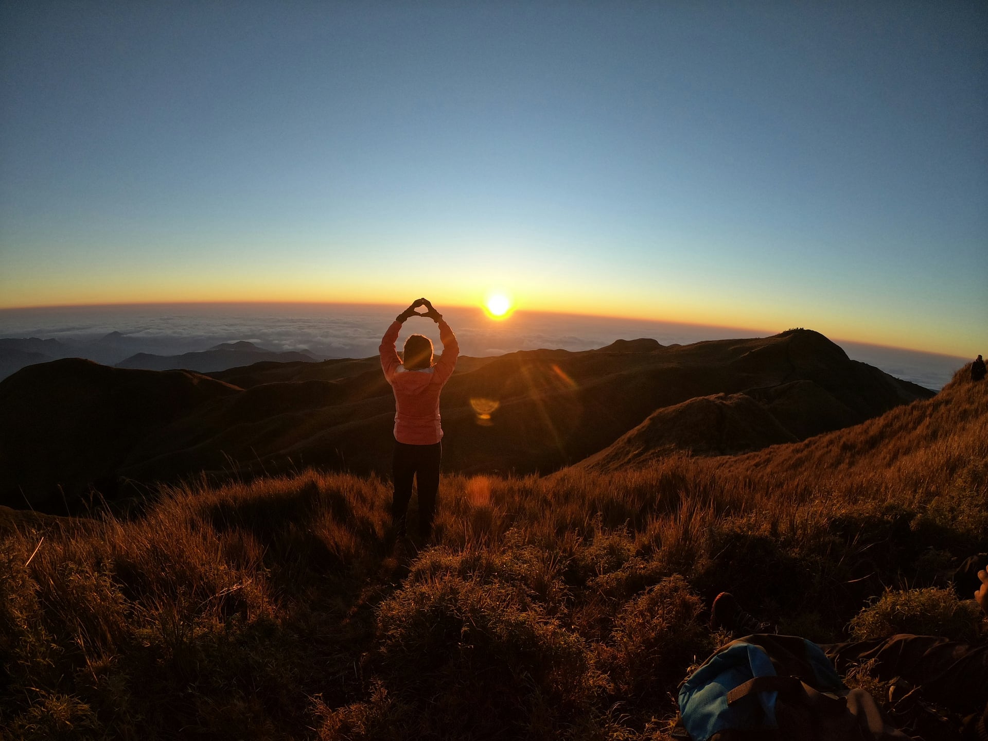 A hiker watching clouds and sunrise from Mount Pulag in the Philippines