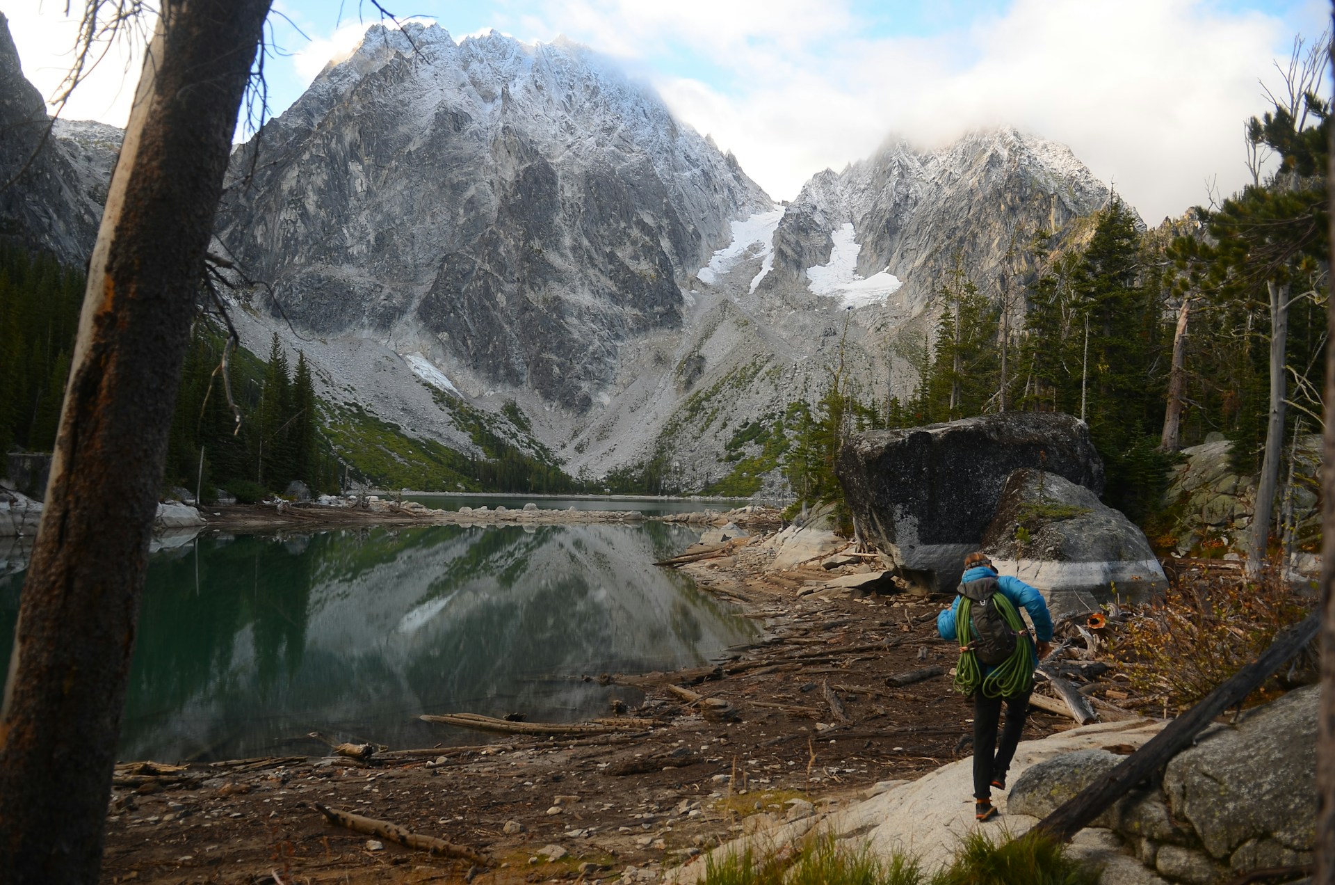 A backpacker hiking beside an alpine lake in the Enchantments
