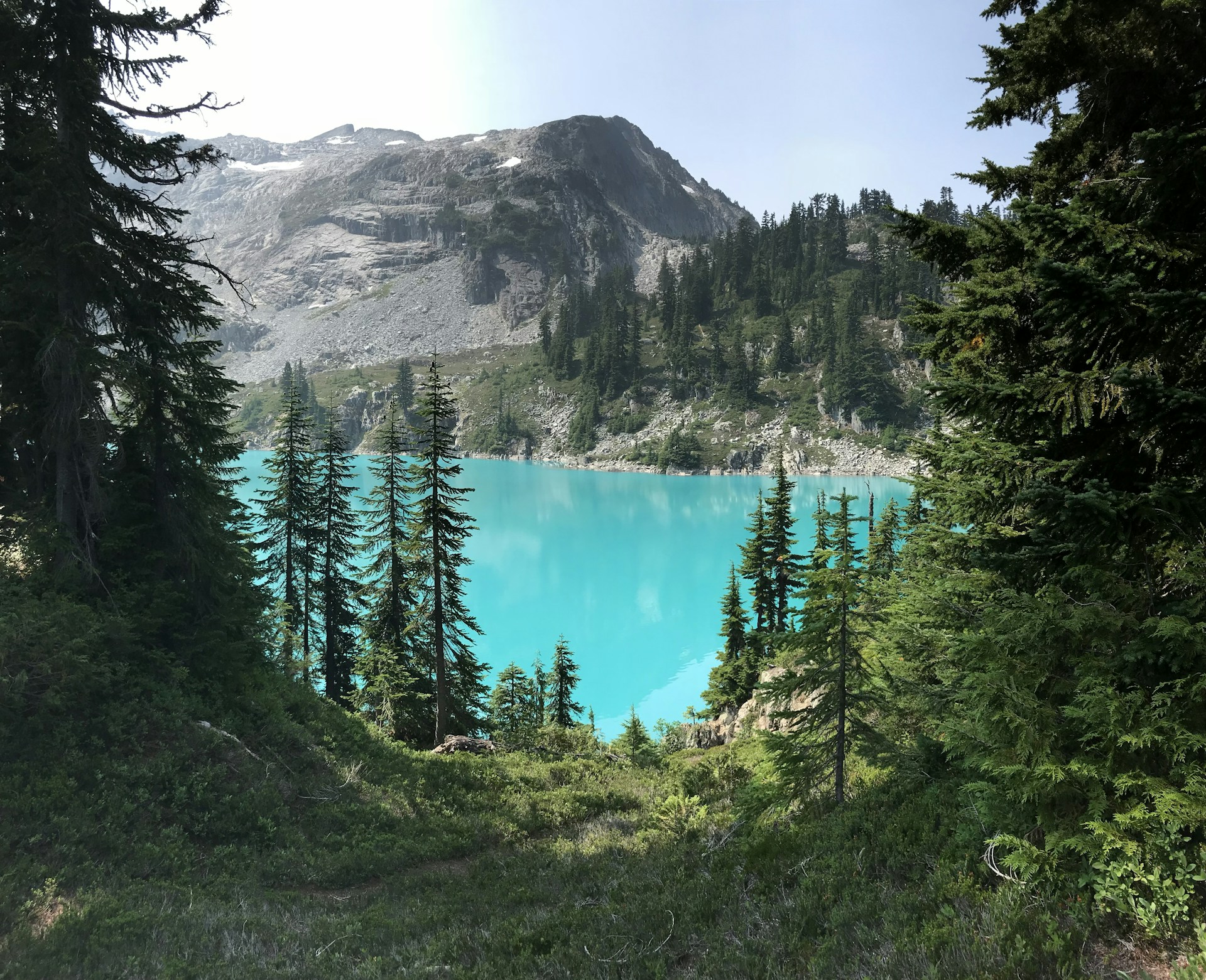 Blue Snow Lake surrounded by forest and mountains in Washington