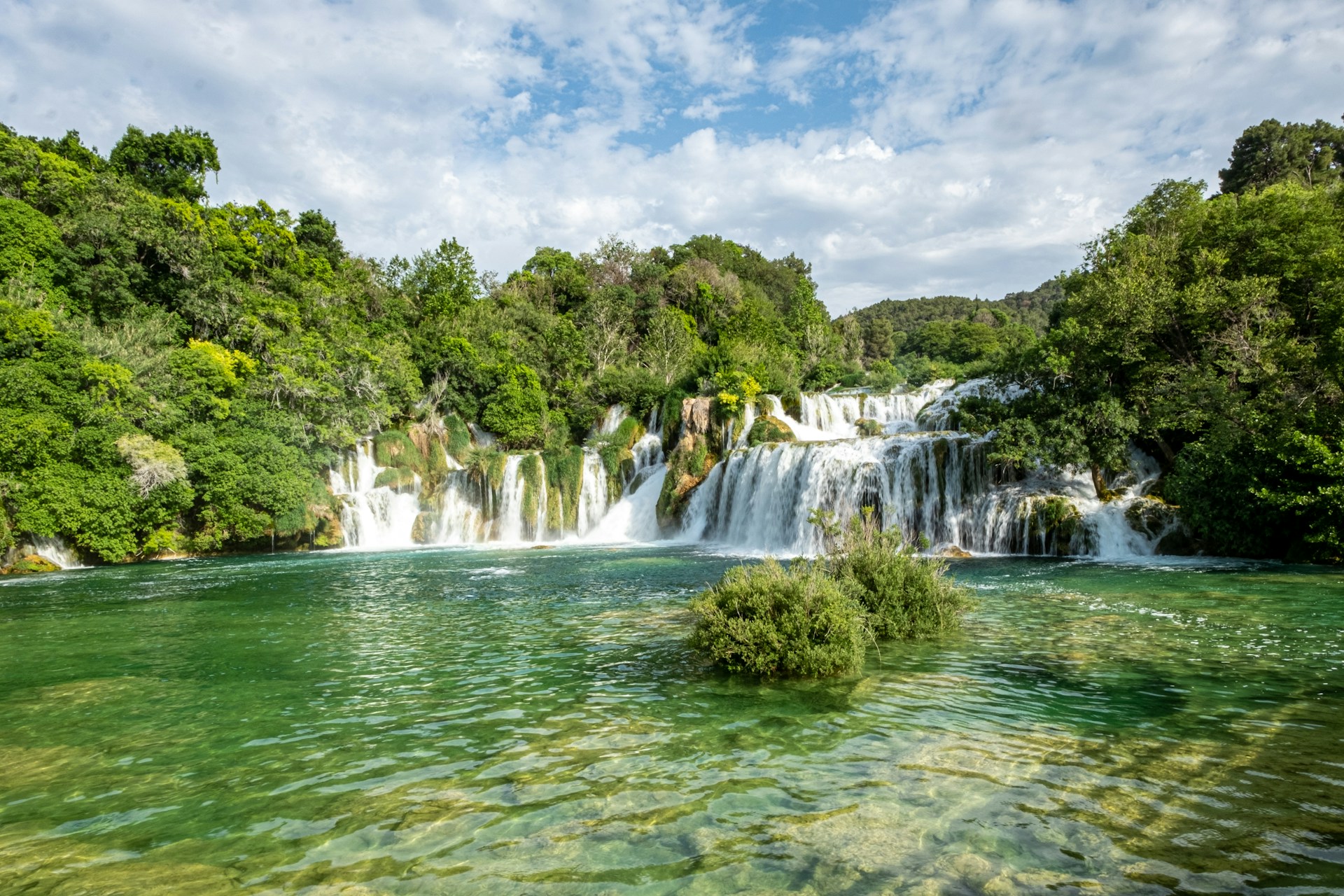 Waterfalls cascading through dense green forest in Krka National Park