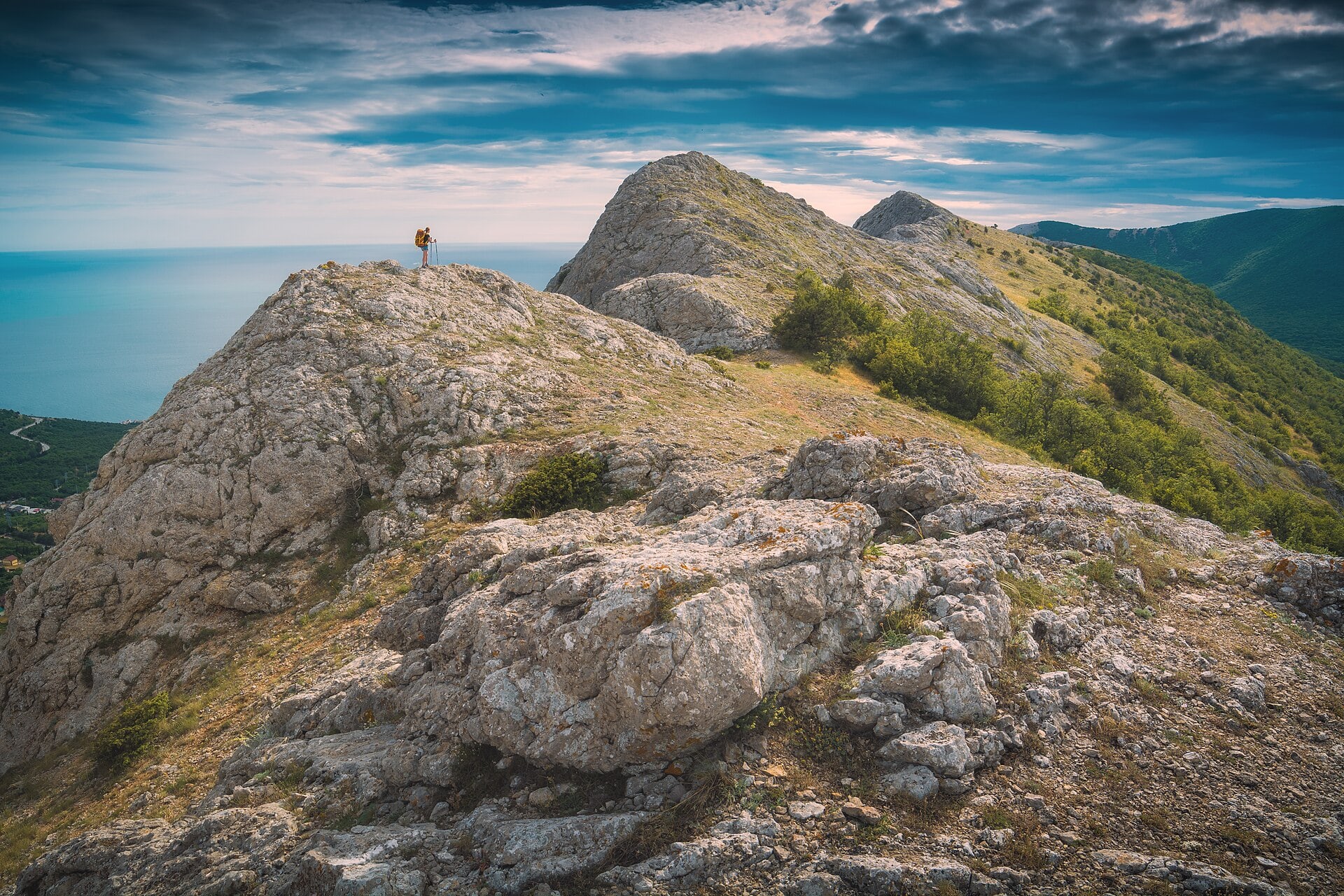 A backpacker dressed for the trail on a rocky summit