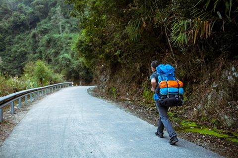 Hiker wearing trail clothing and carrying a colorful backpack
