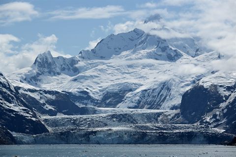 Tidewater glacier descending from snow-covered mountains into Glacier Bay