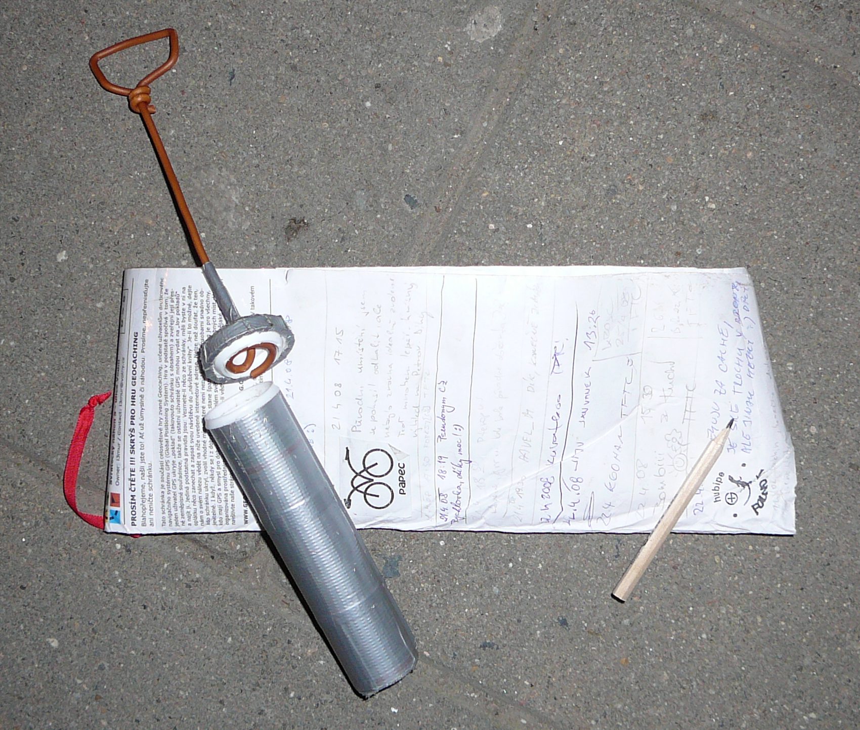A geocache container opened to reveal its logbook
