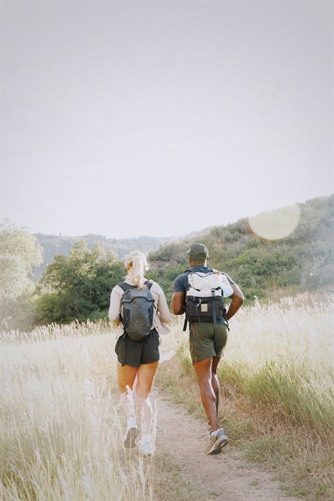 Two hikers exercising together on a sunny trail
