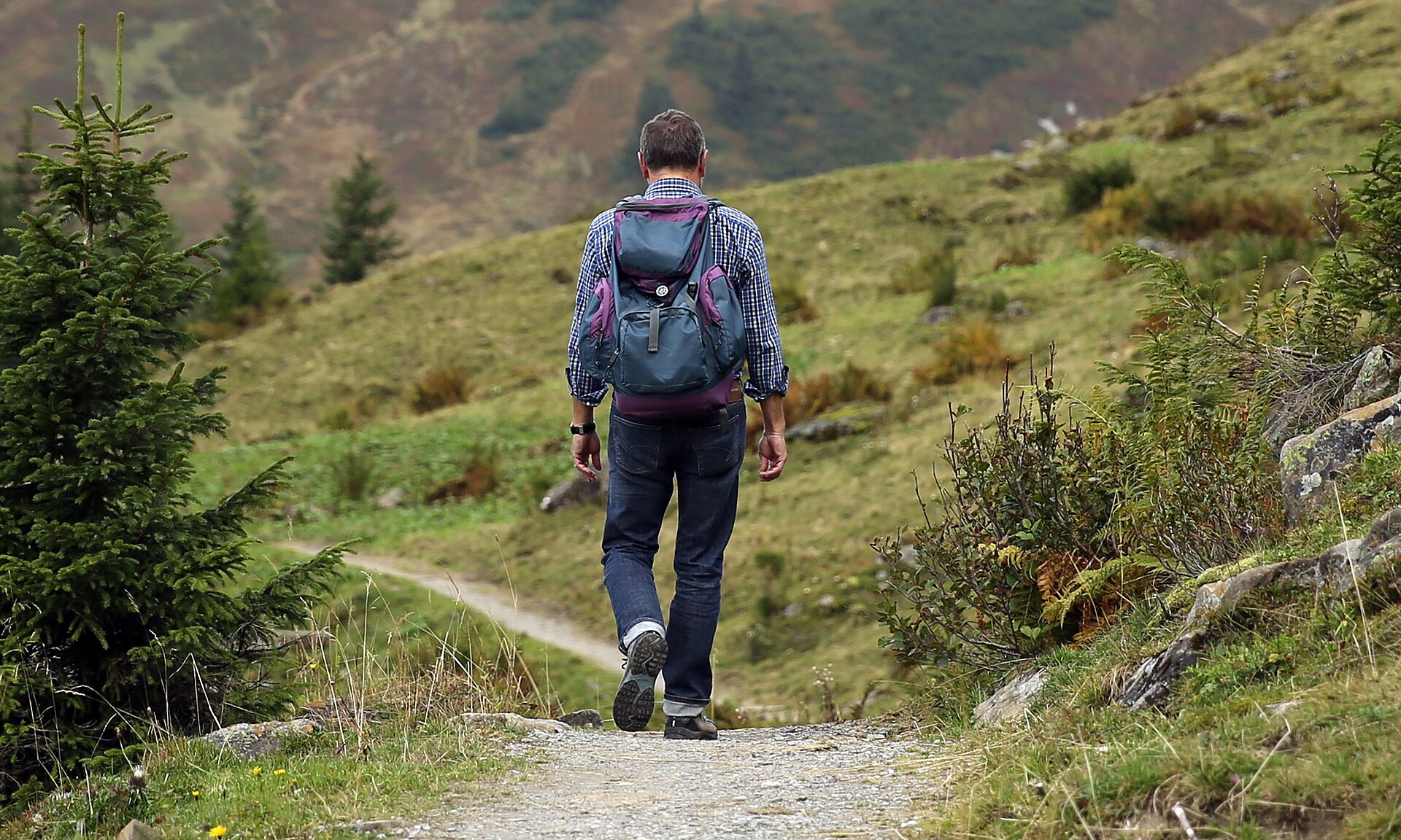 A hiker walking through open mountain terrain