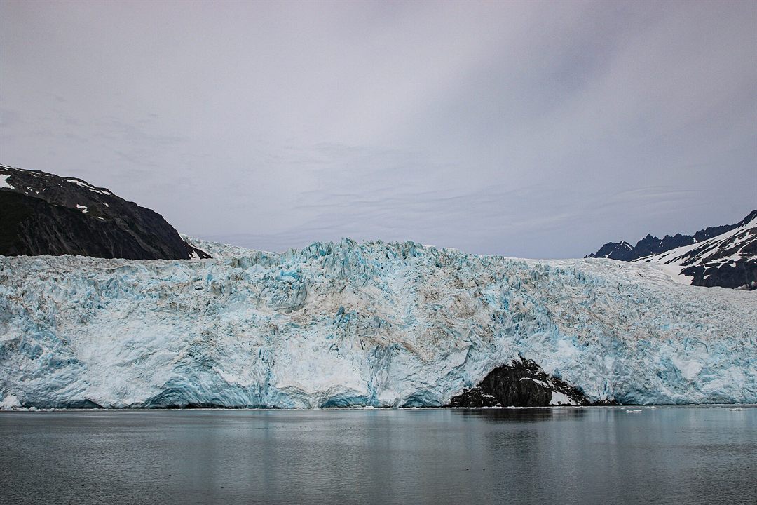 Glacier descending through mountains toward a fjord in Kenai Fjords National Park