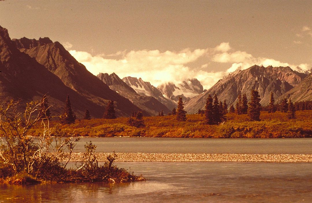 Mountains reflected in the blue water of Lake Clark National Park and Preserve