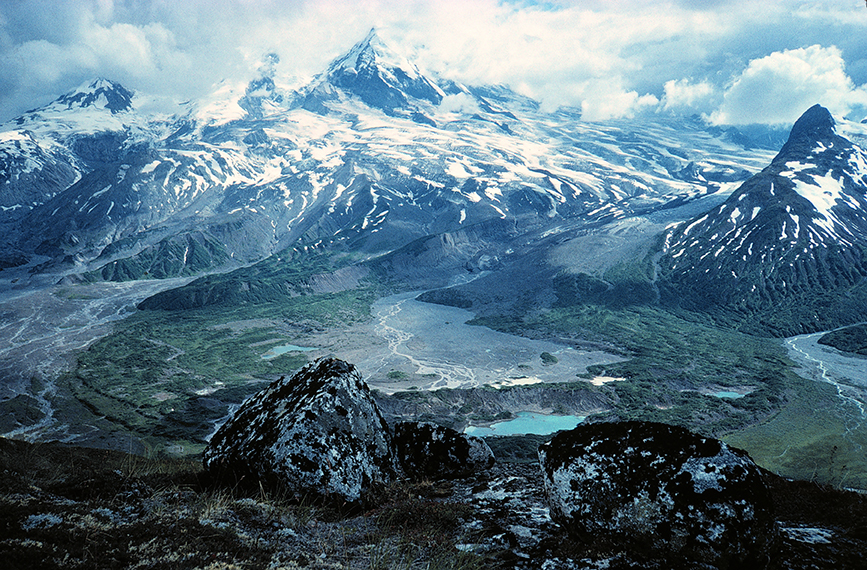 A glacier-flanked volcano rising above a Lake Clark river valley
