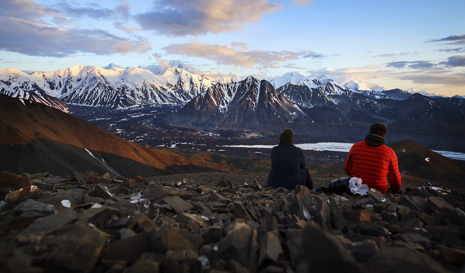 Backpackers eating dinner with the Alaska Range in the distance