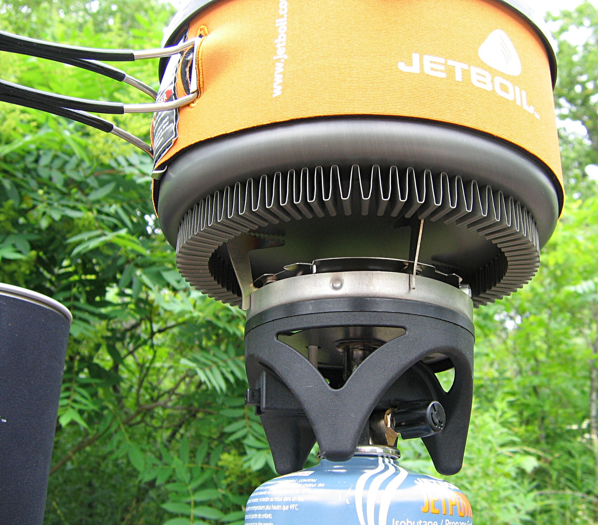 A compact camping stove beneath a cooking pot