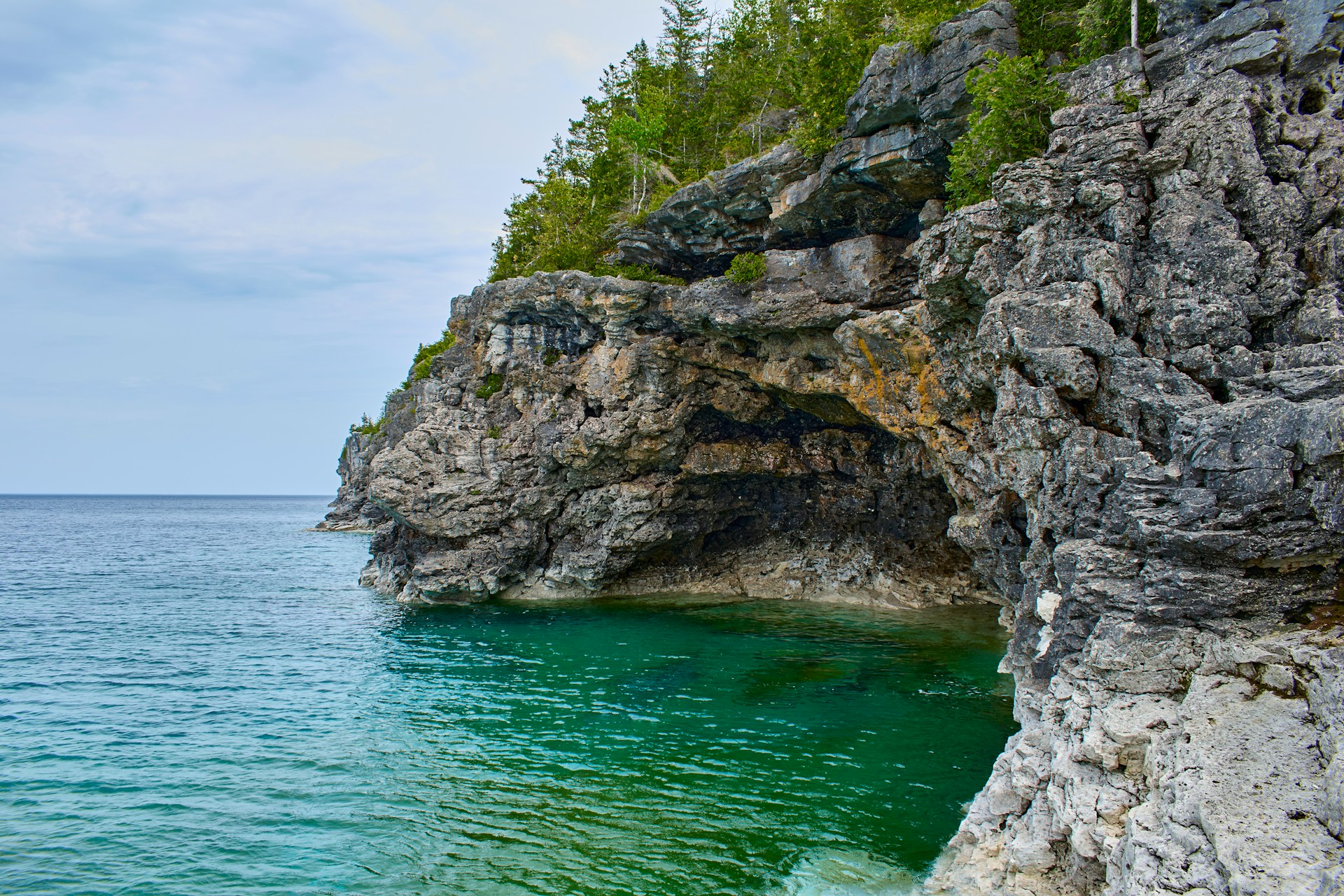 Rock cliffs above the clear blue water of the Grotto in Bruce Peninsula National Park