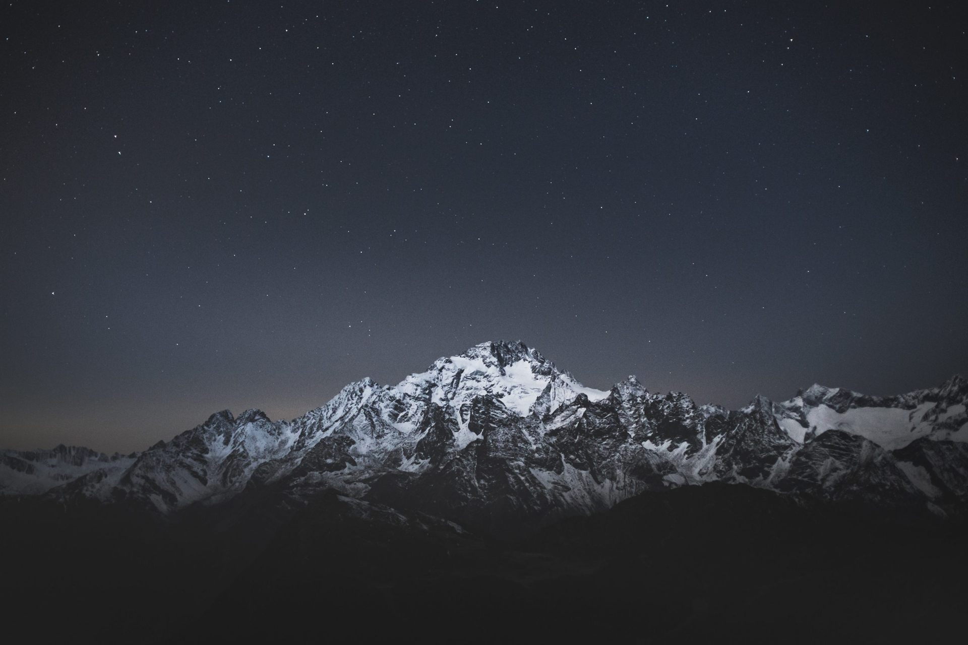 snow covered mountain under blue sky during night time