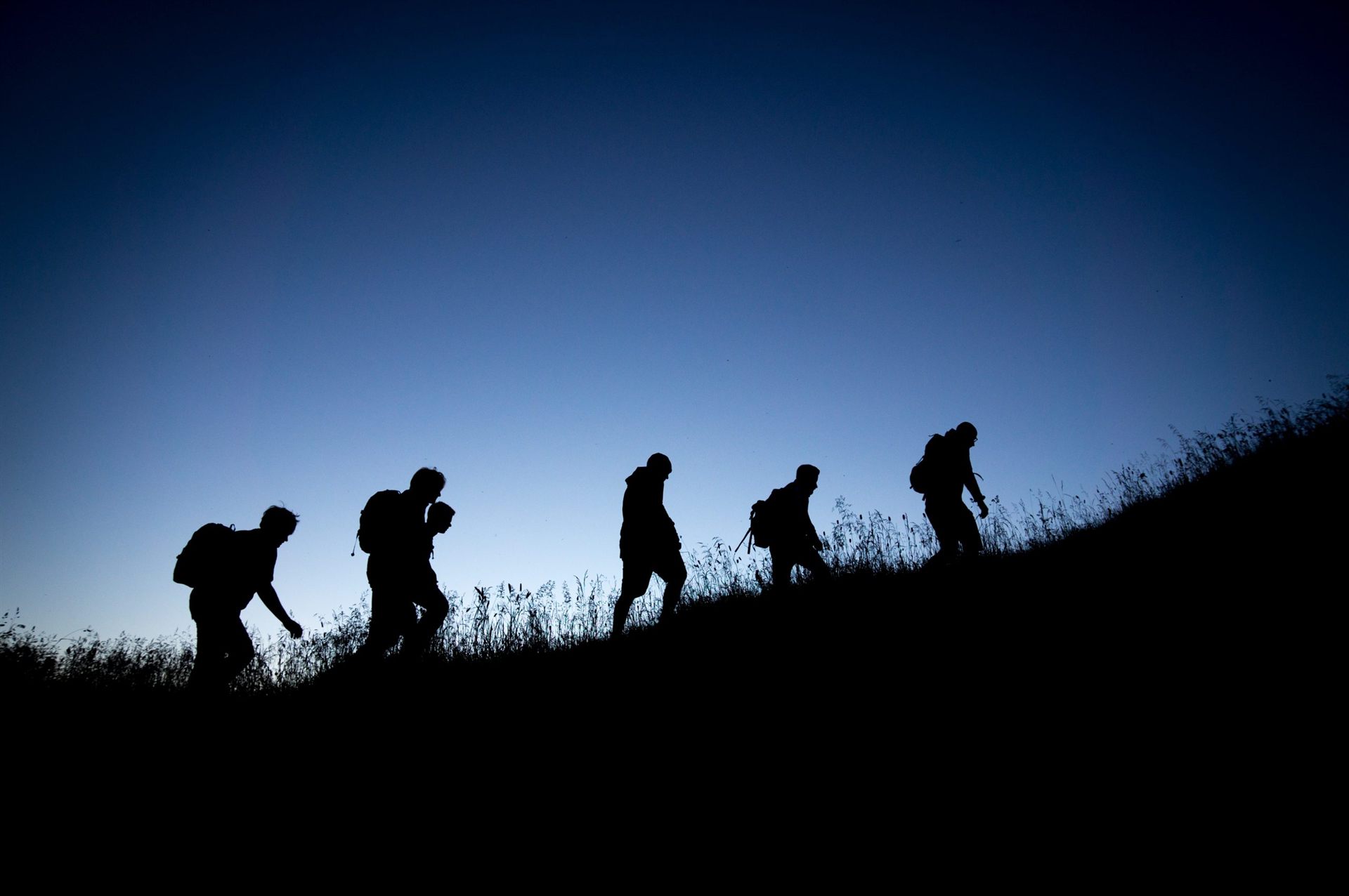 silhouette of people hiking at night