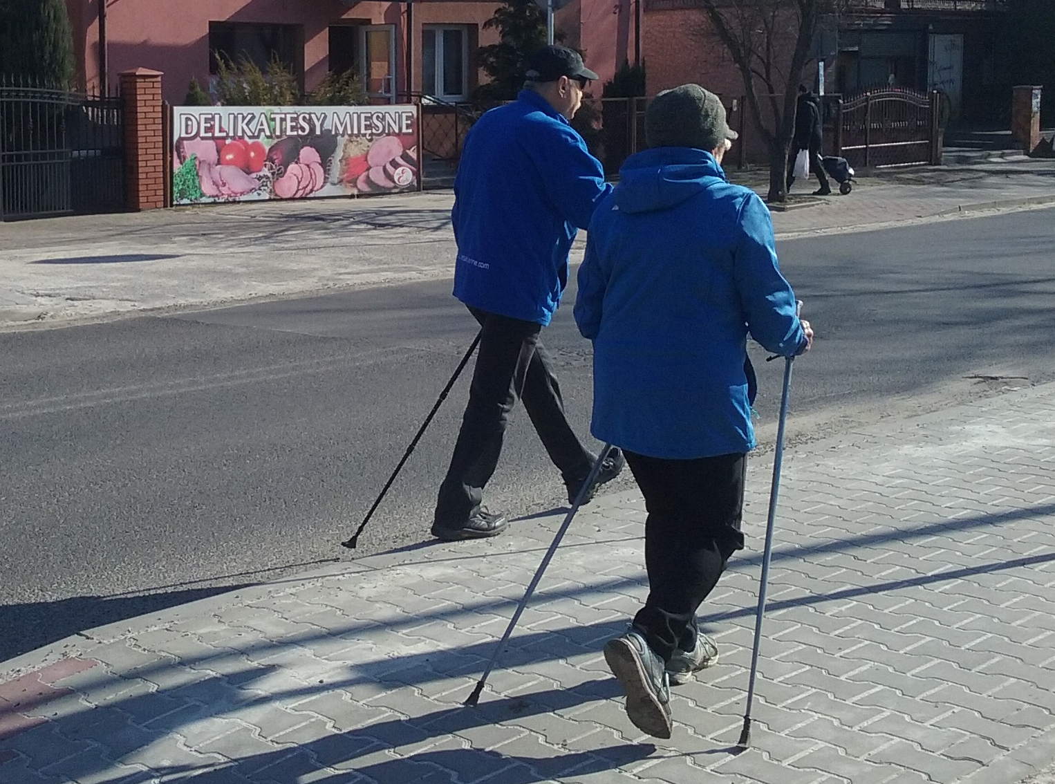 Two Nordic walkers practicing their technique on a street