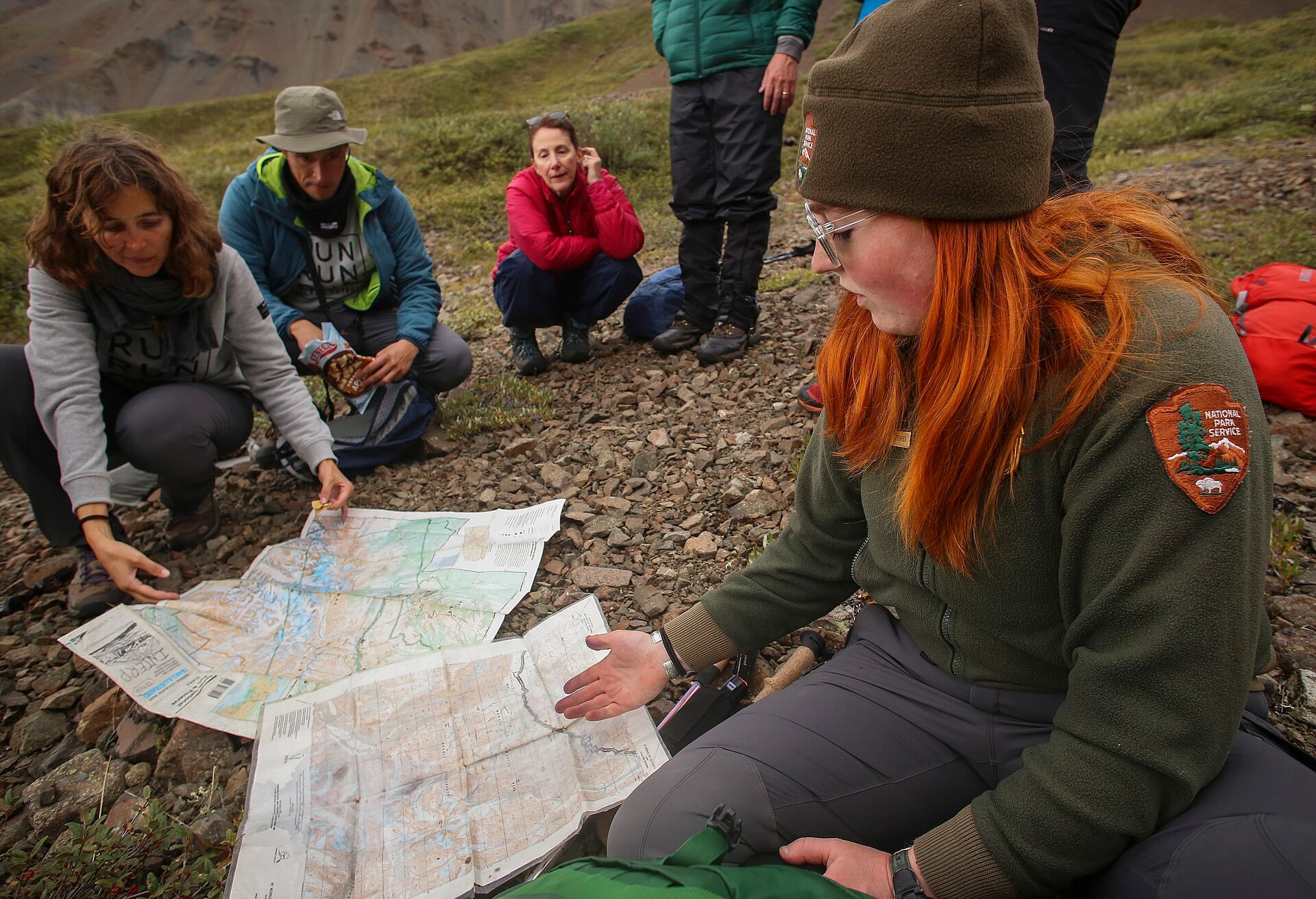 A park ranger teaching hikers to read a topographic map