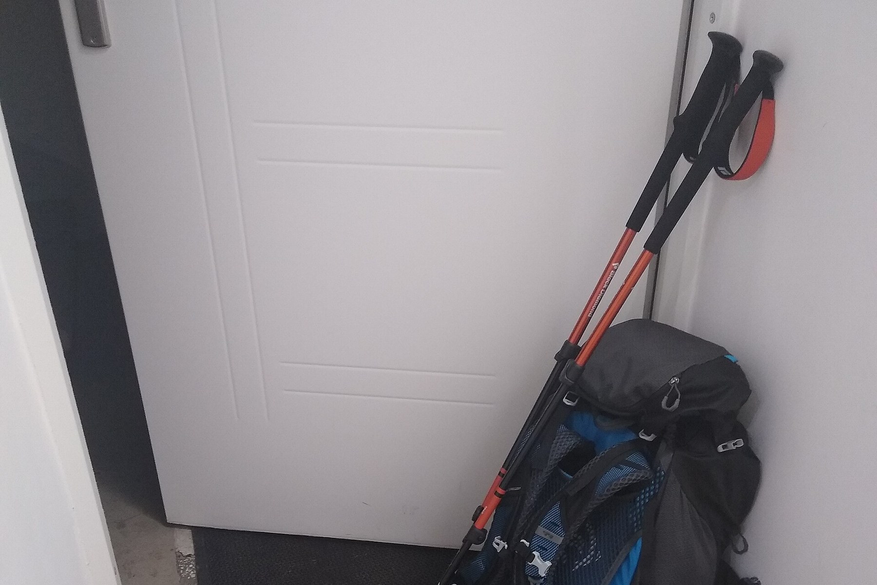 A backpack with trekking poles and hiking shoes