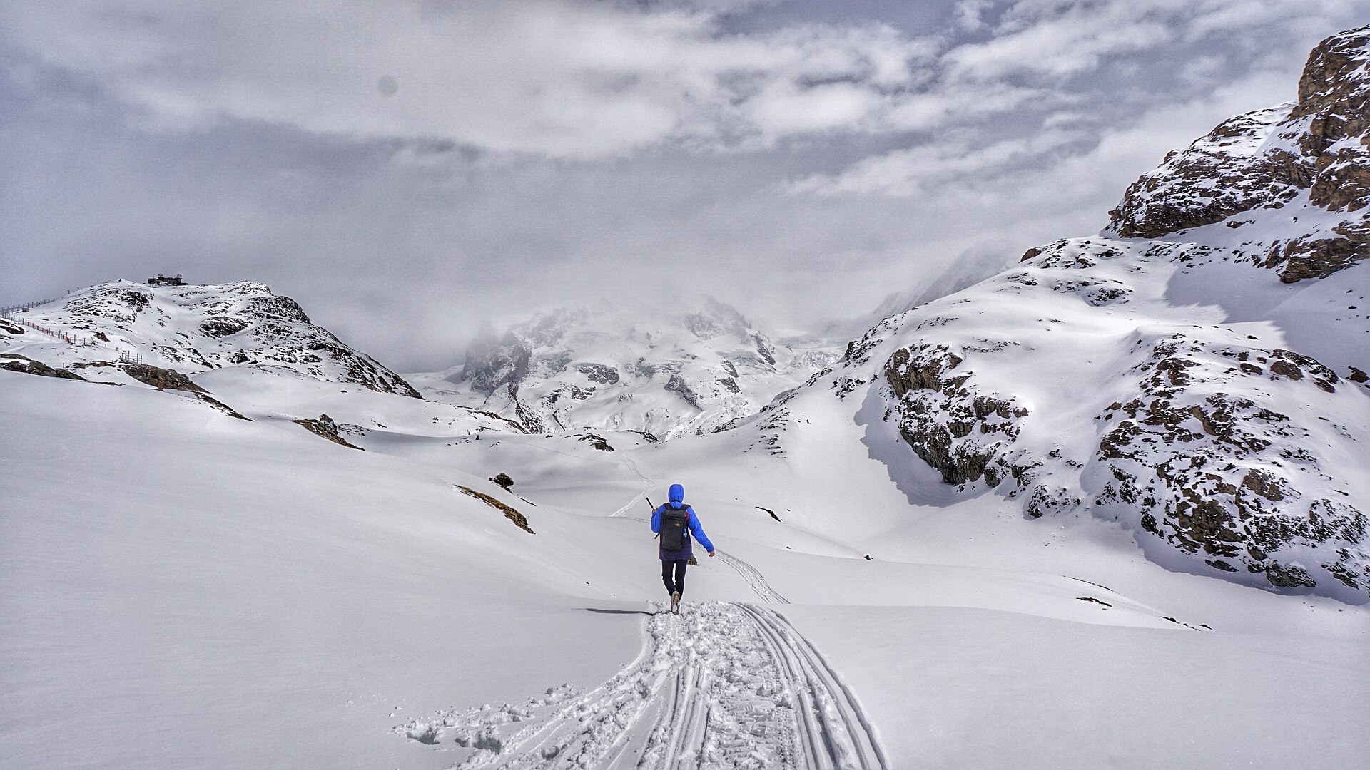 A solo hiker crossing a mountain landscape