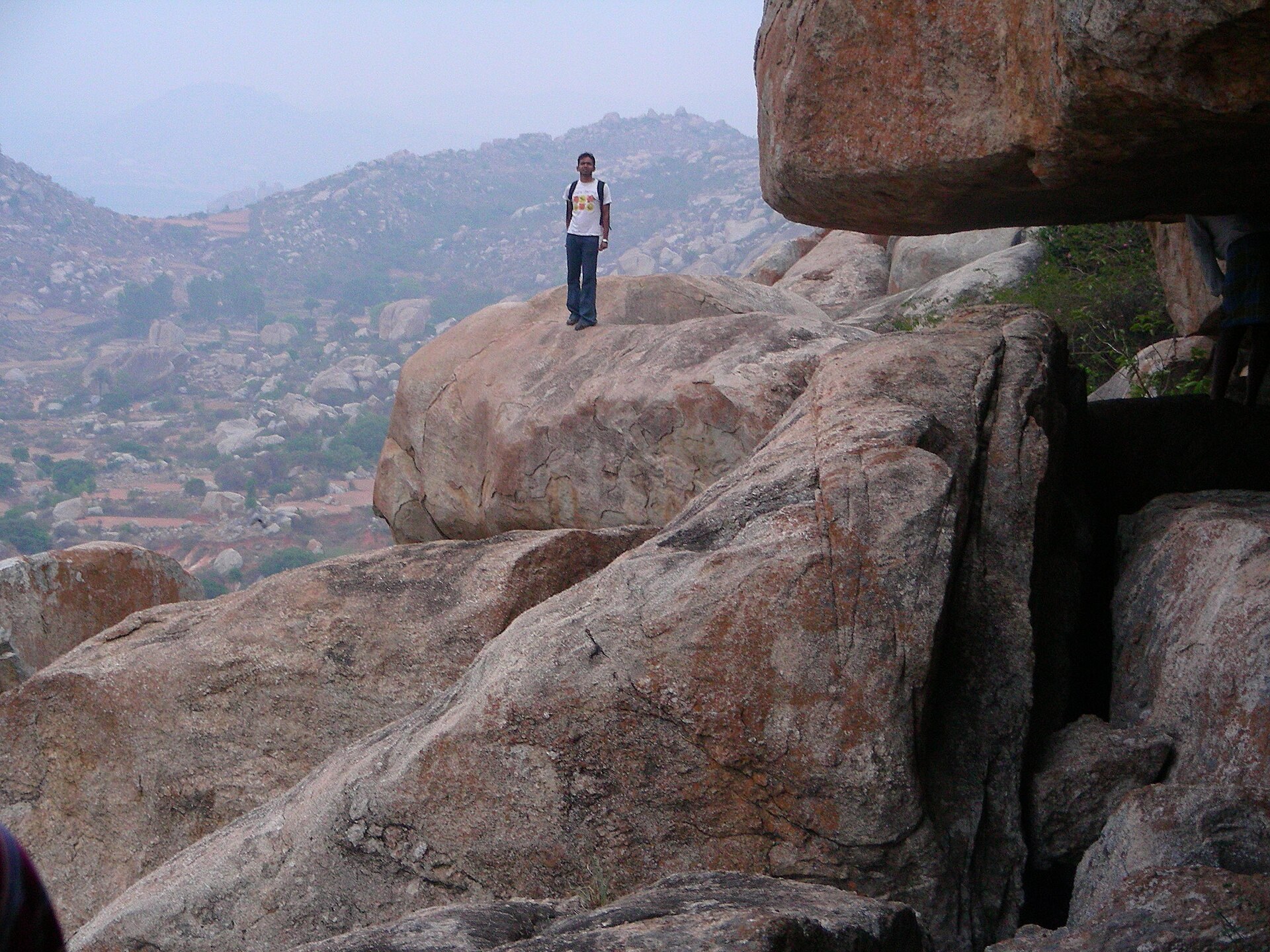 A solo hiker overlooking a broad natural landscape