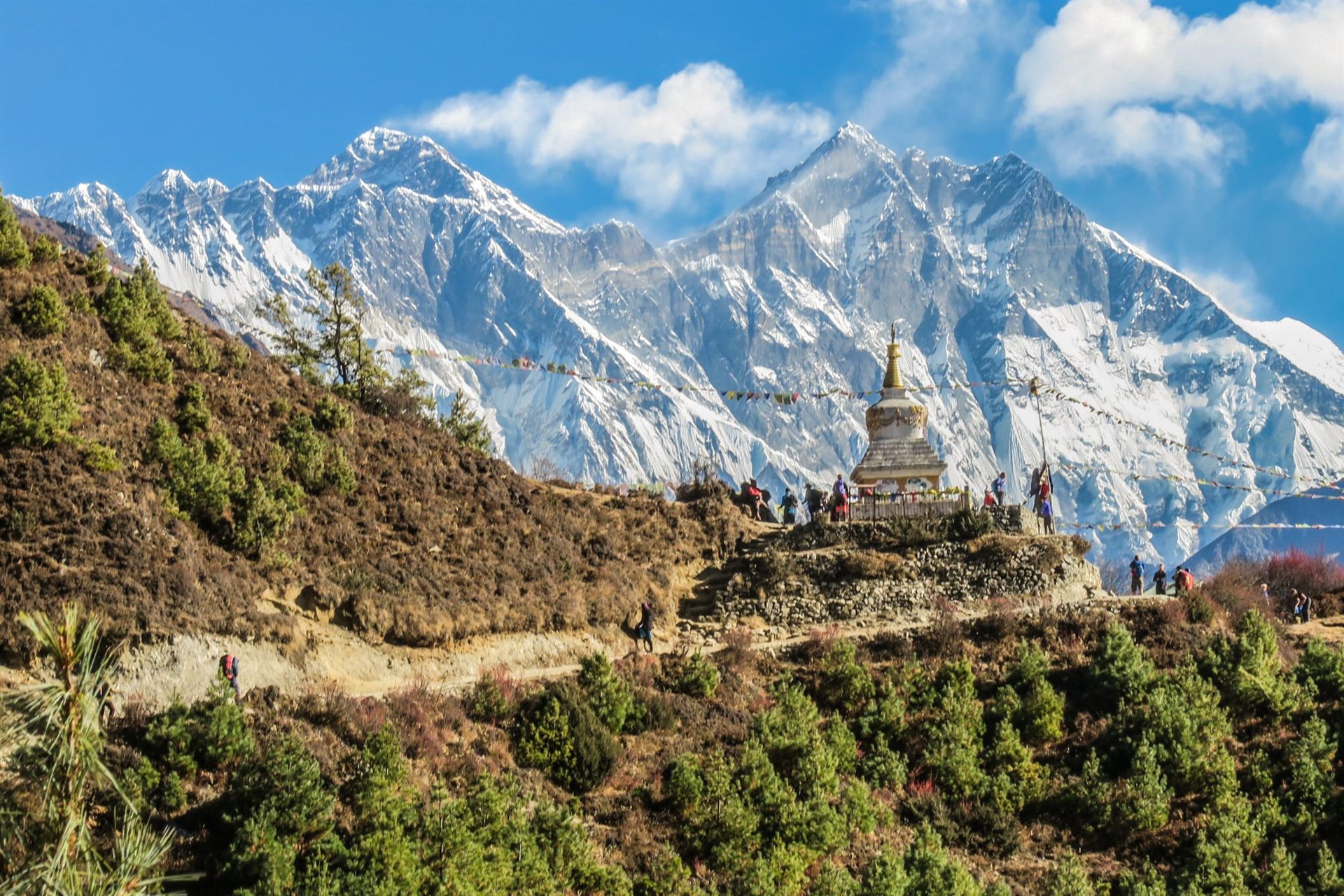 Hikers Taking a Break at a Stupa in Nepal Mountains