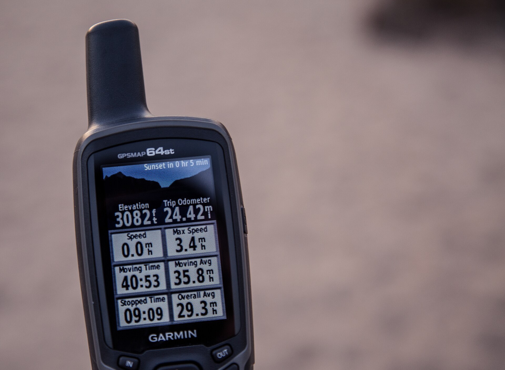 A handheld Garmin hiking GPS on the trail
