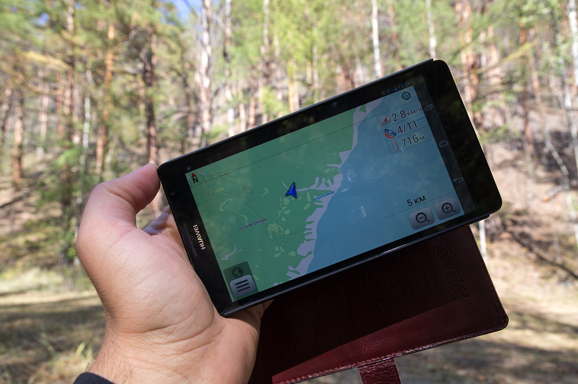 A hiker using smartphone GPS navigation outdoors